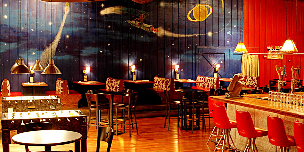 The main room at Buffalo Billiards with bar seating and a painted night sky mural